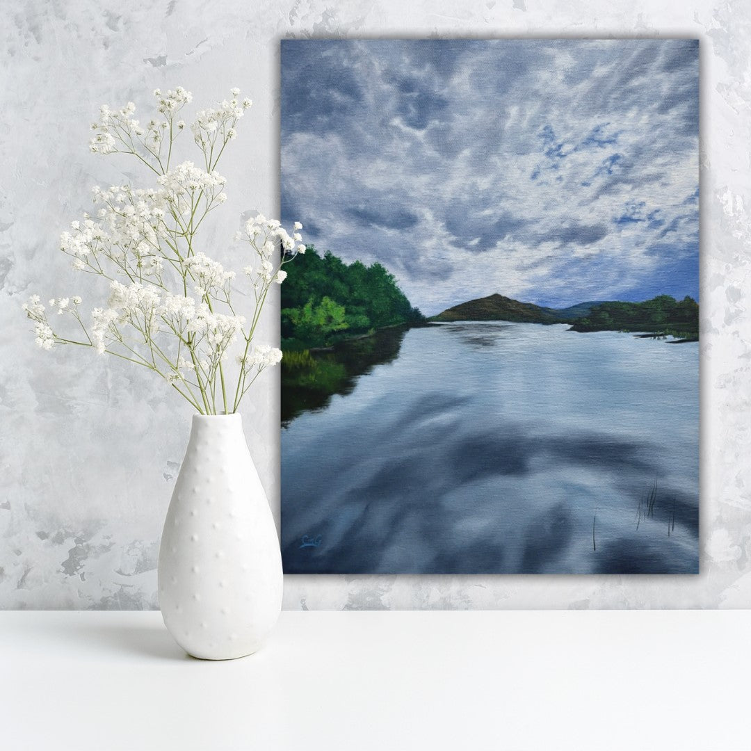 Landscape painting of a still lake with the reflections of storm clouds with light shining through - oil painting