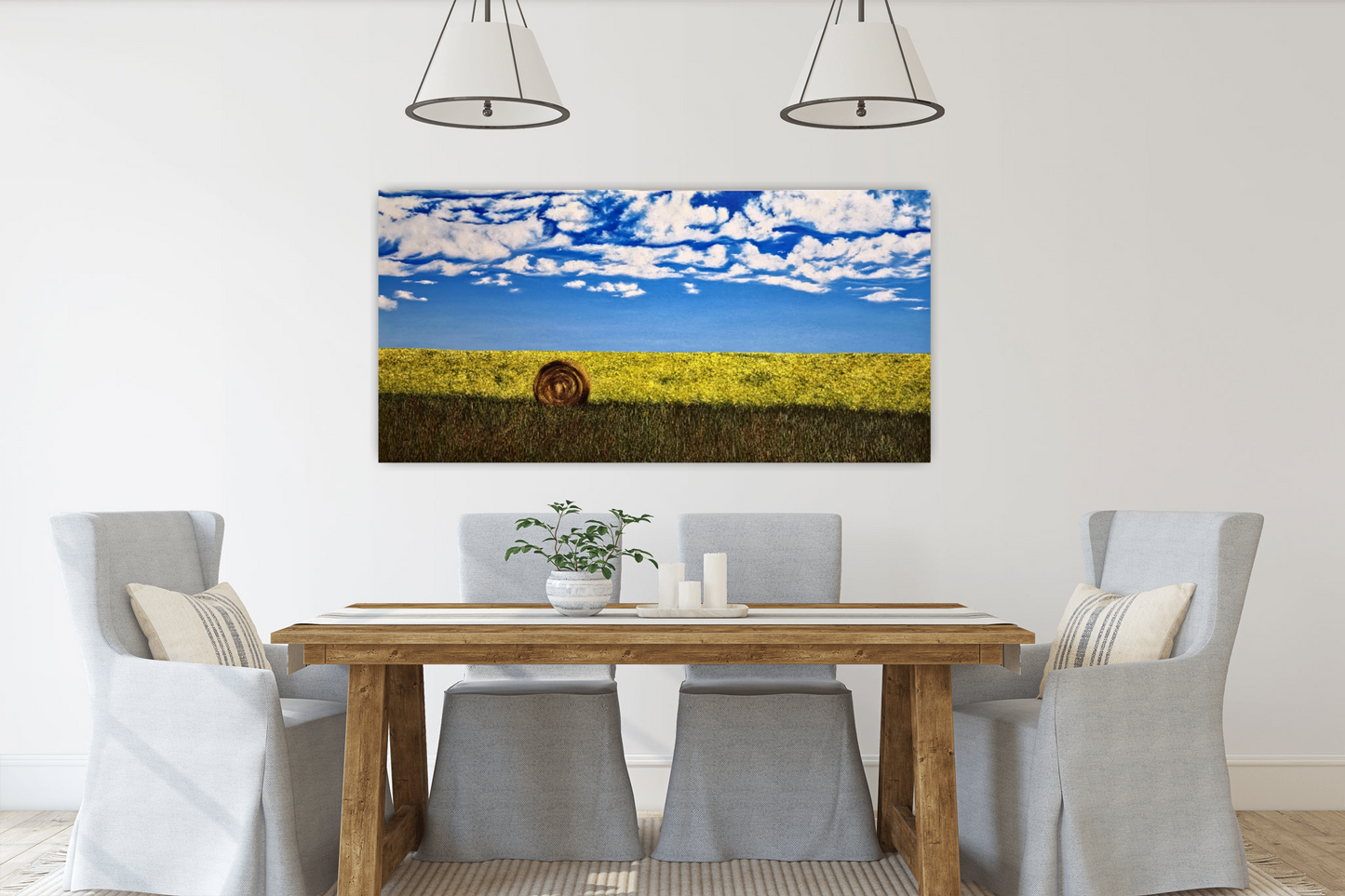 Bumper Crop and original oil painting of a hay bale and canola field hanging on the wall in a dining room