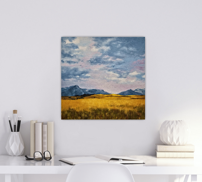 Christina Gouldsborough original oil painting of a wheat field with mountains in the background and lilac hued sky, on a white wall behind a desk with white accents