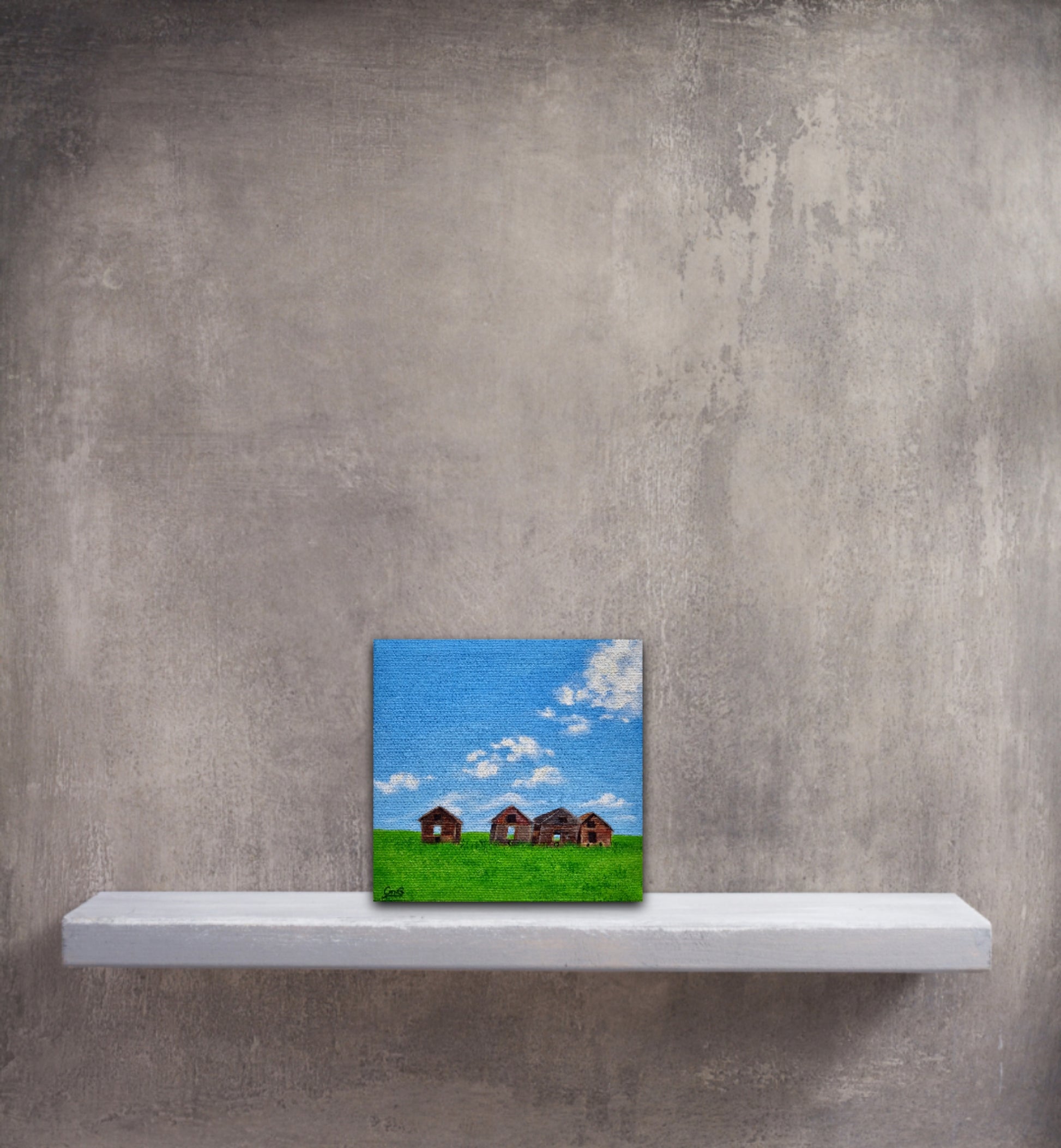 Small original oil painting of 4 vintage sheds in a green field in summer in front of a grey wall on a grey shelf