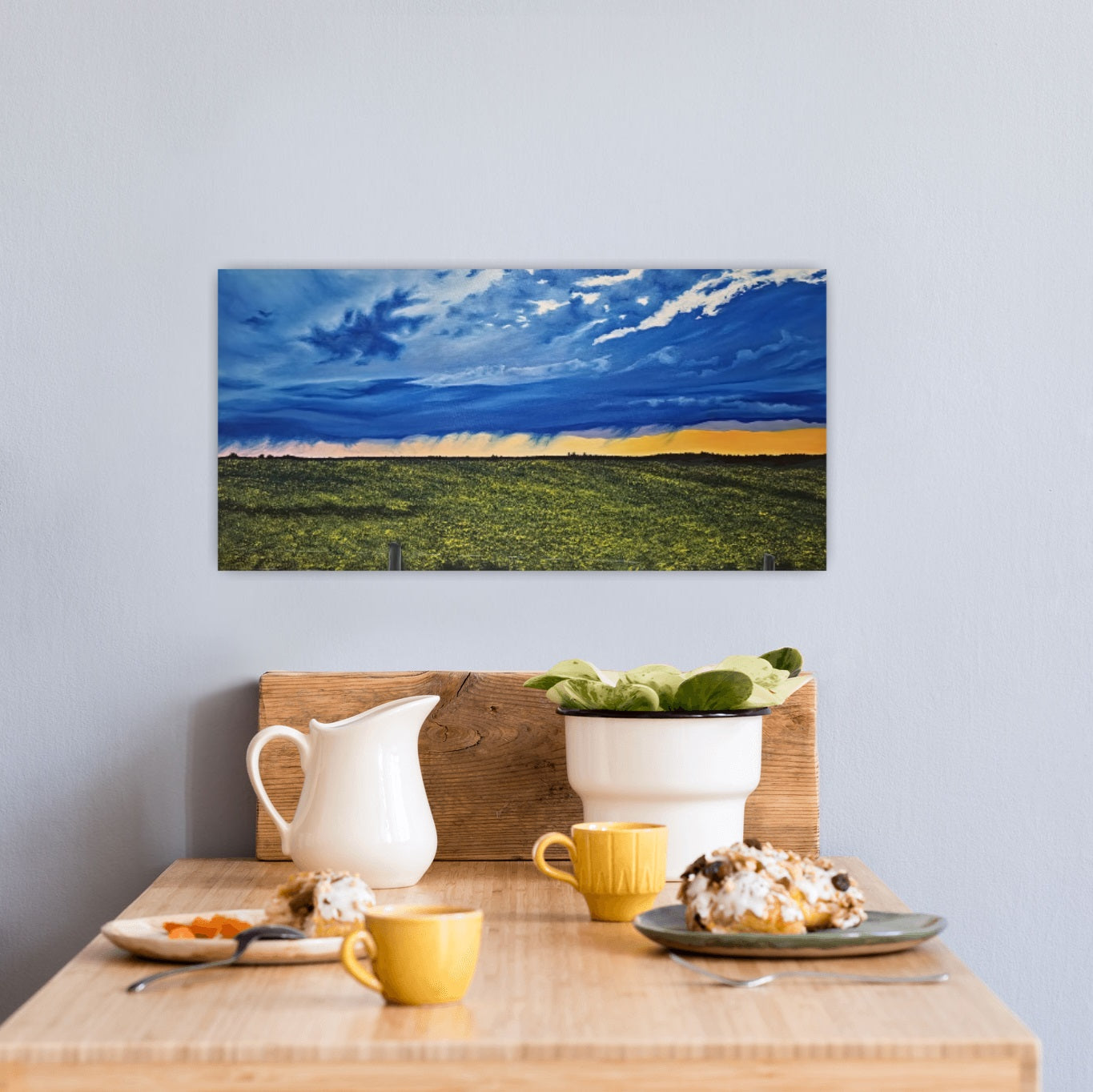 Happy Hour and original oil painting by Christina Gouldsborough of a vibrant sunset after a summer storm over the canola fields , over a breakfast table with food and drinks